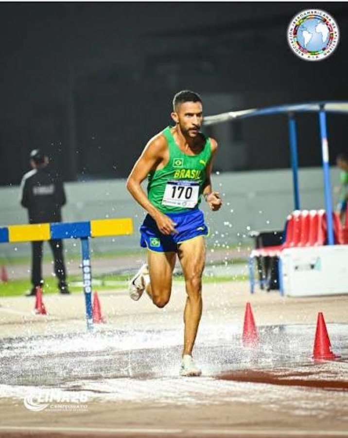 Atleta brasileiro competindo em prova de obstáculos com água, uniforme da seleção